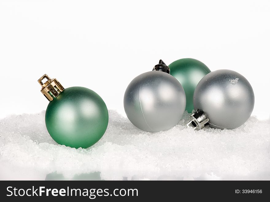 Four Christmas balls on white snow