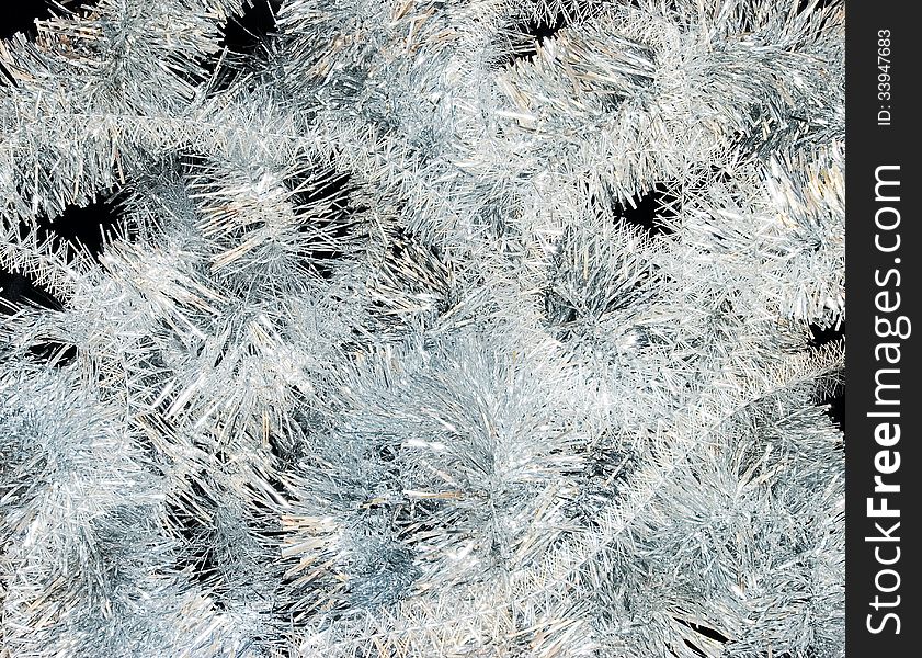 Christmas background of silver tinsel on a black