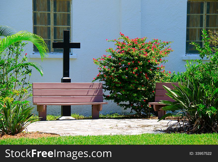 Outdoor church prayer garden with a cross, benches and plants. Outdoor church prayer garden with a cross, benches and plants.