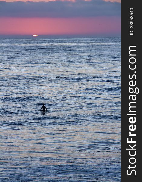 Silhouette of a surfer and paddle-boarder watching the sunset. Silhouette of a surfer and paddle-boarder watching the sunset.