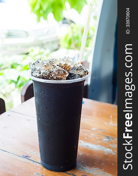 Ice Black Coffee on table wood .