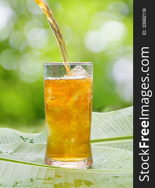 Glass of cold iced tea on Banana leaves ,outdoor.