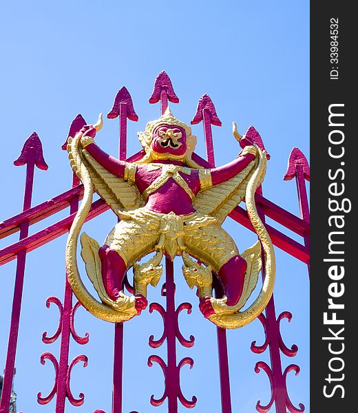 Garuda and Naga on red iron gate.