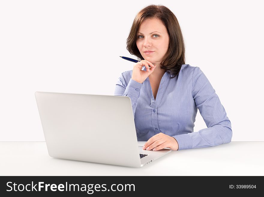 Businesswoman is sitting in front of a modern laptop and looking at the camera, business concept. Businesswoman is sitting in front of a modern laptop and looking at the camera, business concept