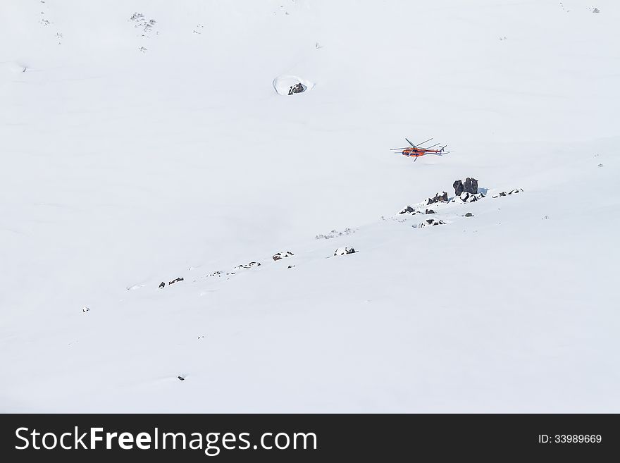 The helicopter on the snow of Kamchatka mountains