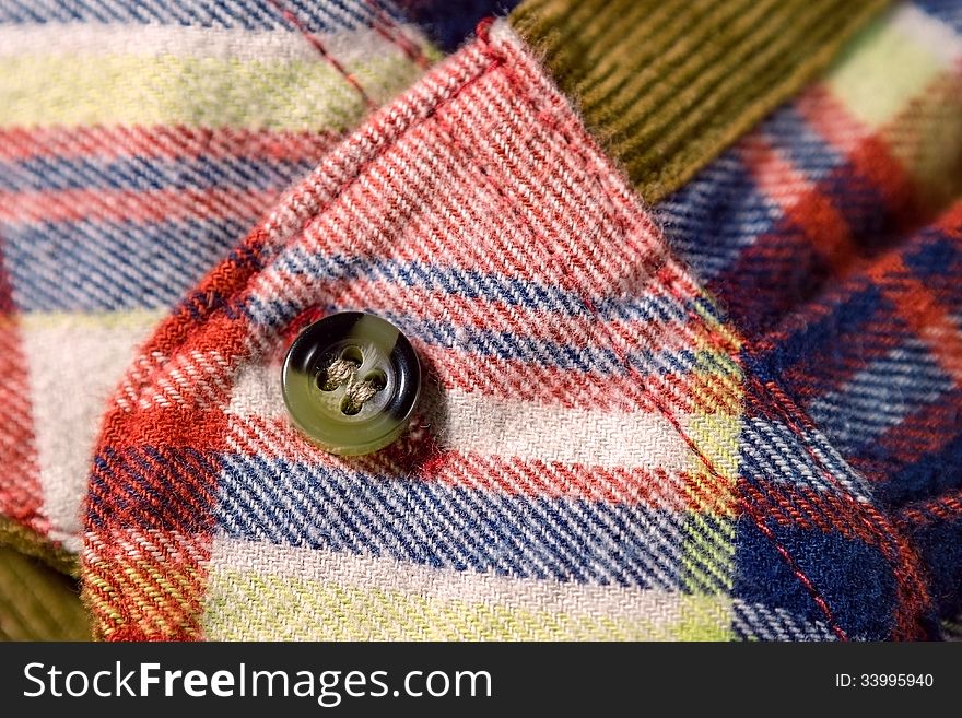 Close up of a checkered shirt cuff with a button