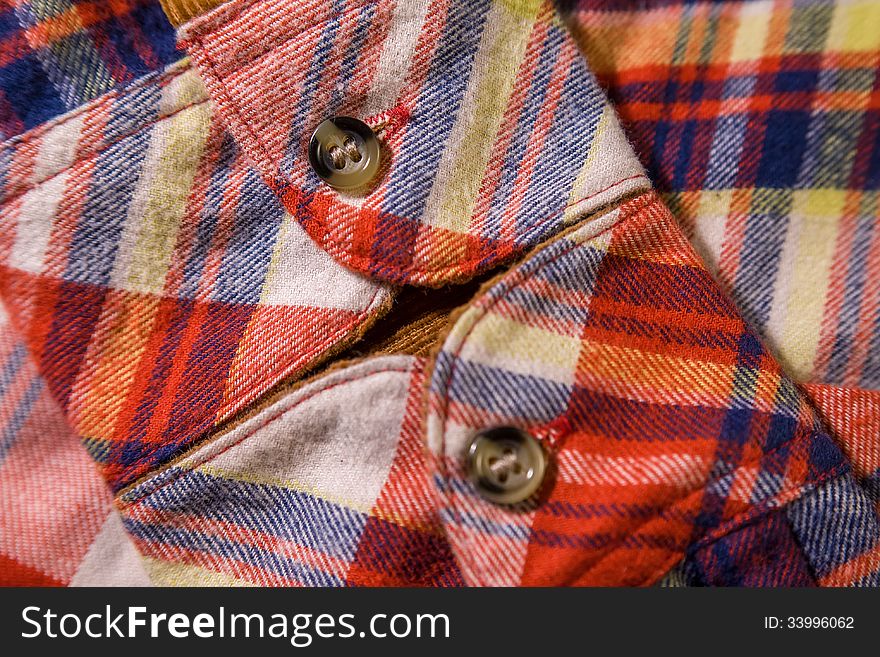 Close up of a checkered shirt cuff with buttons