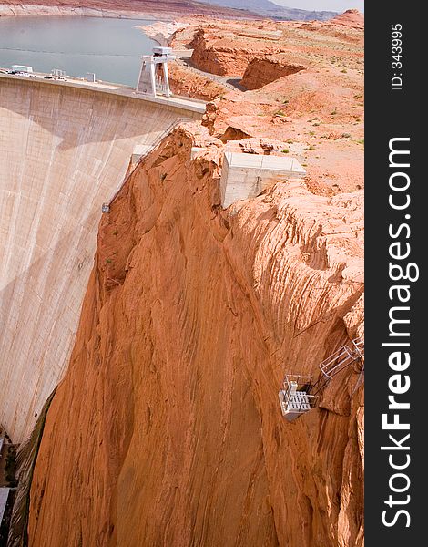 Red sandstone cliffs and the Glen Canyon Dam form Lake Powell in northern Arizona - vertical orientation. Red sandstone cliffs and the Glen Canyon Dam form Lake Powell in northern Arizona - vertical orientation.