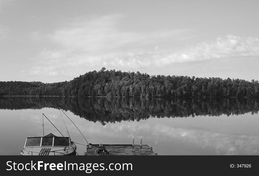 Calm lake reflection of Little Redstone Lake in Haliburton, Ontario