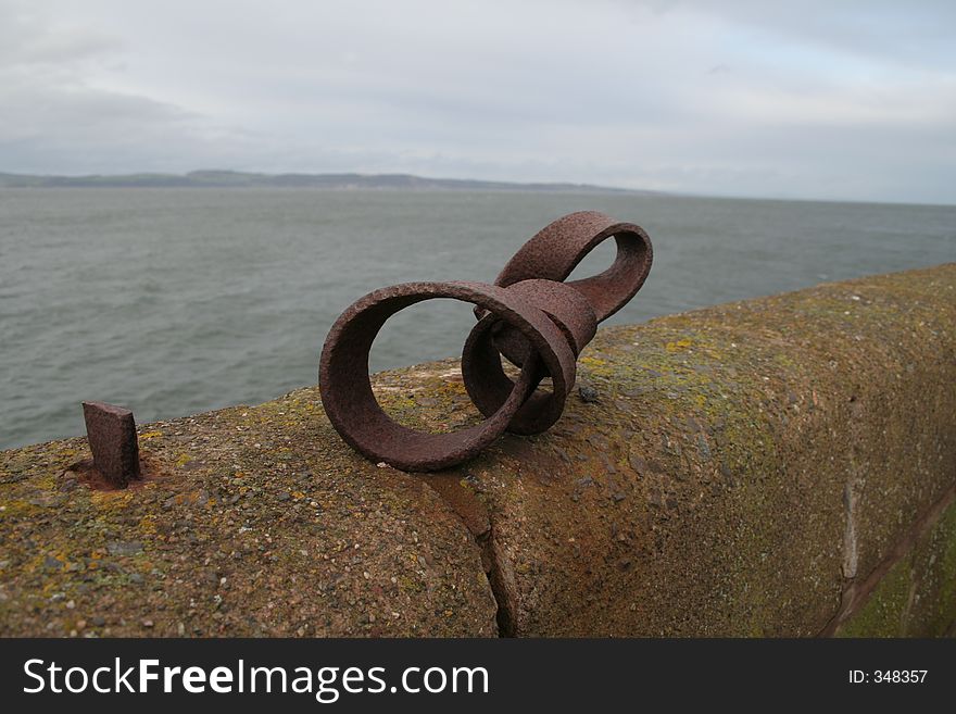 Interesting Colours and textures of Rusty metal loop on a sea wall. Interesting Colours and textures of Rusty metal loop on a sea wall