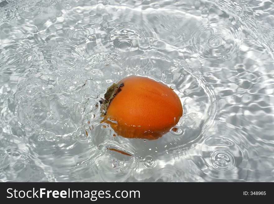 Kaki fruit splashing into water