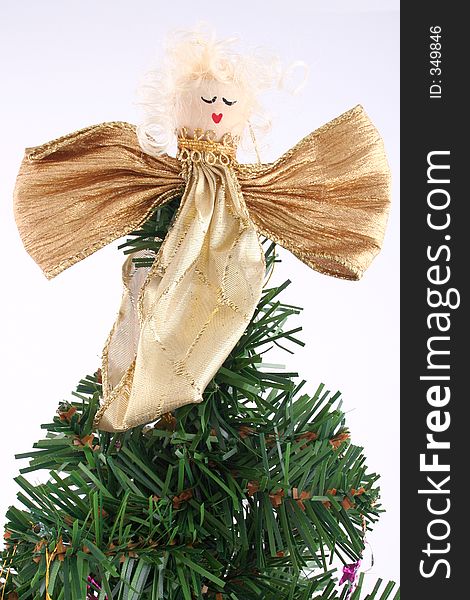 Gold Angel on top of a xmas tree with white background. Gold Angel on top of a xmas tree with white background