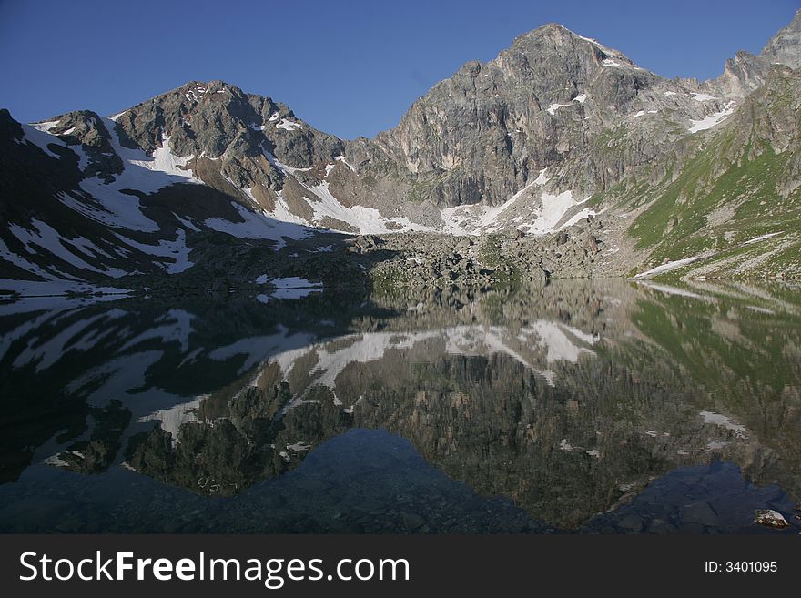 A reflection of mountains is in a lake