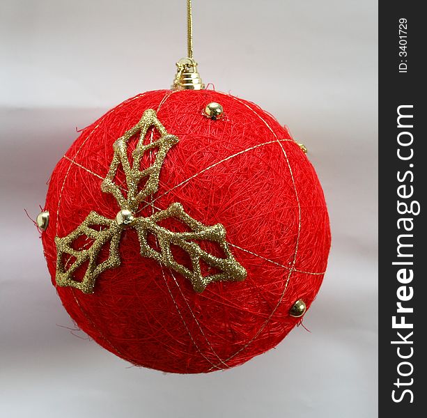 A new-year toy on a fir-tree is red on a bulom background Red christmas decoration strewed by beads