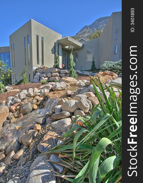 A small section of the front yard with beautiful creek water feature xeriscape landscaping. A small section of the front yard with beautiful creek water feature xeriscape landscaping