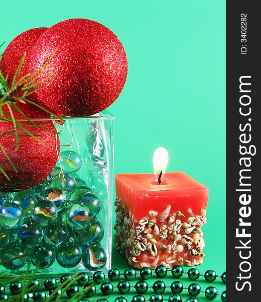 Image from christmas series: meny glass balls and candle on green background. Image from christmas series: meny glass balls and candle on green background