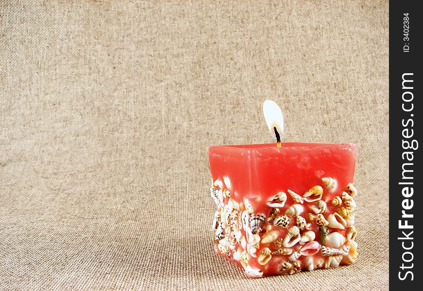 Home series: red candle on beige tissue