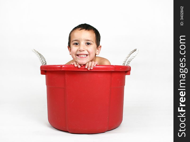 A young boy smiling in a tub. A young boy smiling in a tub