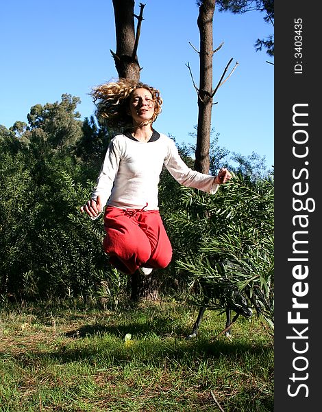 Digital photo of a woman jumping in a forest.
