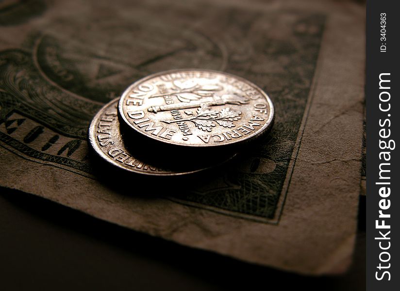 This is a closeup of two dimes tails up on a dollar bill. This is a closeup of two dimes tails up on a dollar bill.