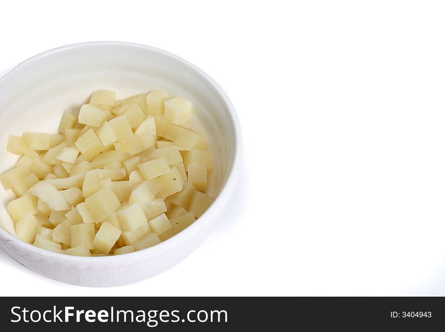 Bowl of potato cubes on isolated white background horizontally