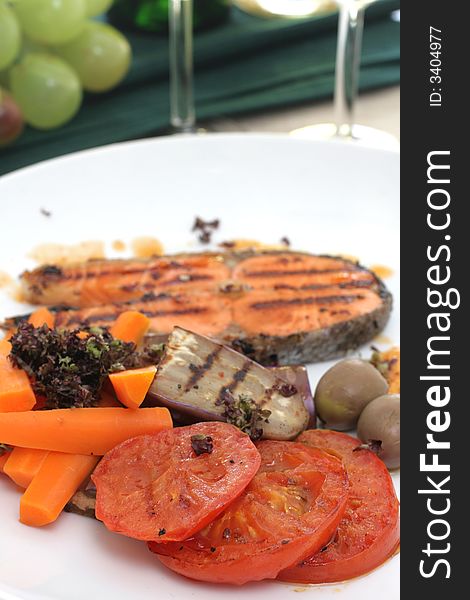 Pan seared salmon served with brinjal, carrots, sliced tomatoes and white wine