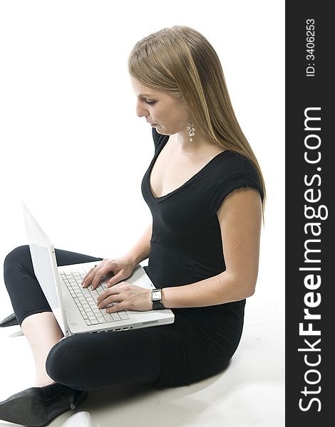 Beautiful young blond woman sitting with a white laptop computer. Beautiful young blond woman sitting with a white laptop computer.