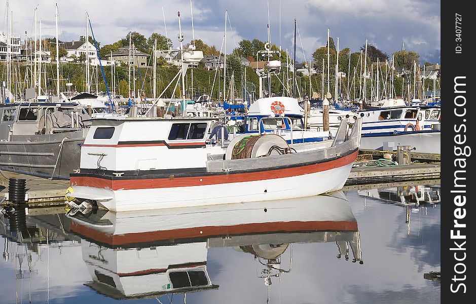 A red and white boat at a pier in a marina