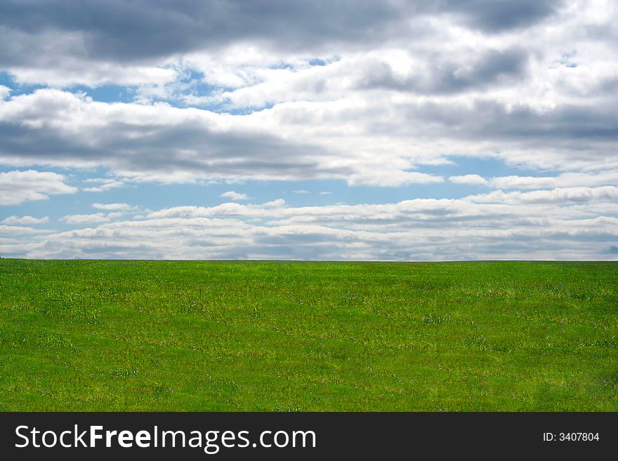 A Green field and blue sky and clouds