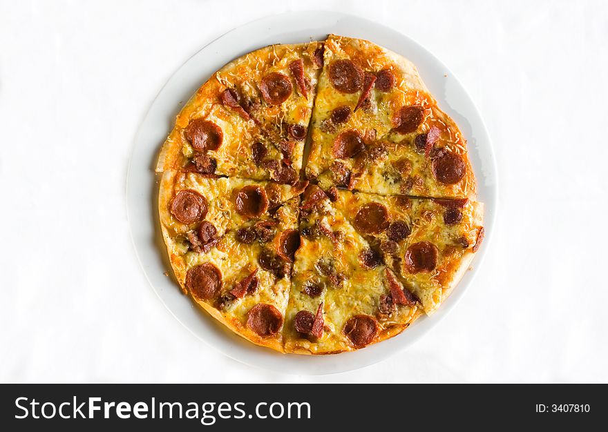 Detail shot of hot fresh pepperoni pizza isolated against a white background with great colors and depth of field. Room for text. Detail shot of hot fresh pepperoni pizza isolated against a white background with great colors and depth of field. Room for text.