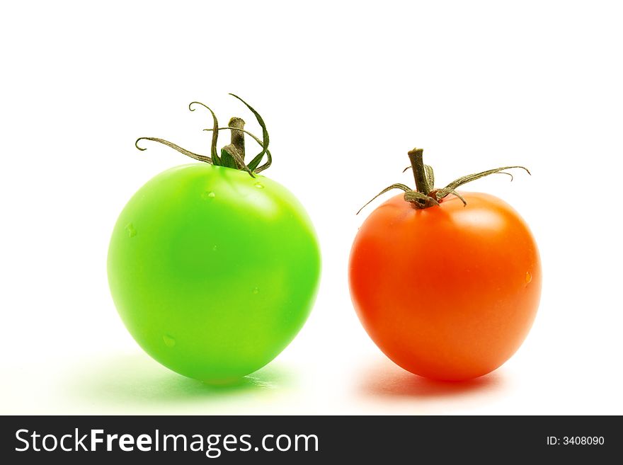 Close up of a red and a green round tomato on white background. Close up of a red and a green round tomato on white background