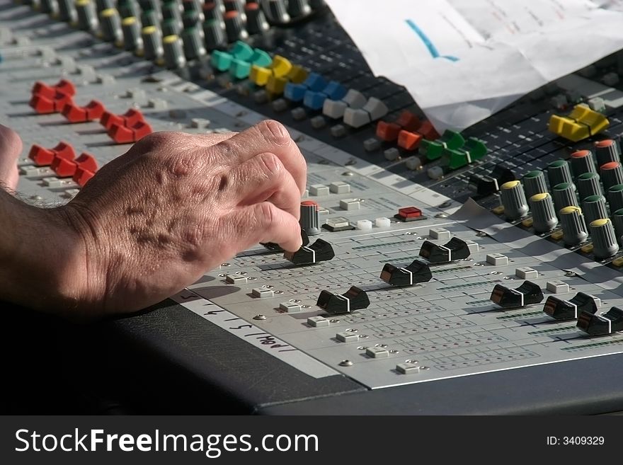 Hand of an sound or music mixer in action
