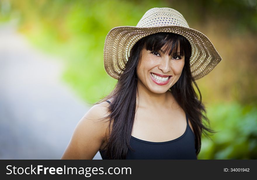 Spanish girl with a hat smiling at the park