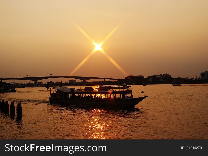 Shuttle boat crossing a river in Bangkok at sunset. Shuttle boat crossing a river in Bangkok at sunset