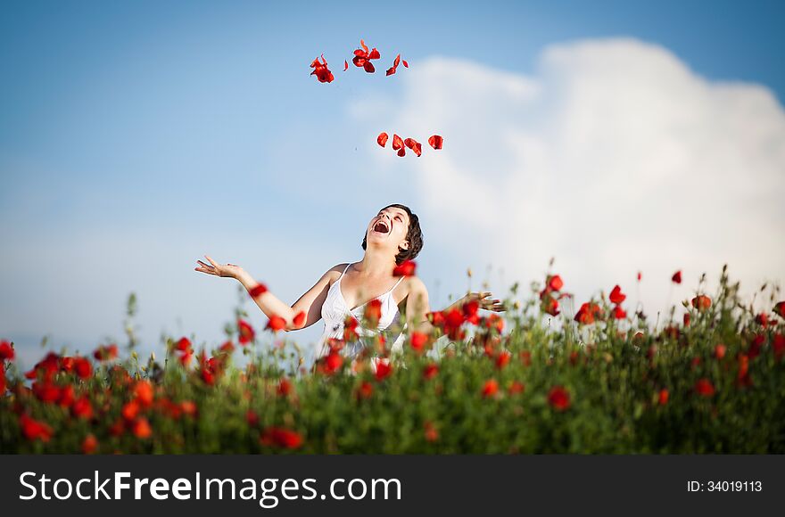 Pregnant happy woman in a flowering poppy field