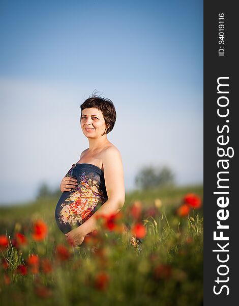 Pregnant Happy Woman In A Flowering Poppy Field