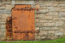 Rustic Metal Door In Stone Wall Stock Photo