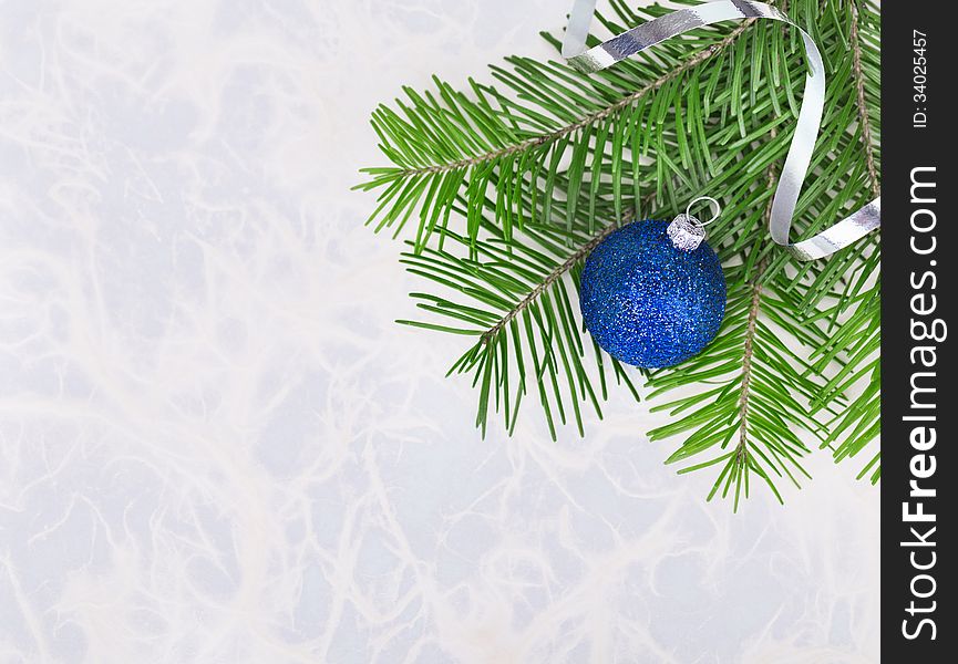 Christmas ball with fir-tree twigs on abstract background