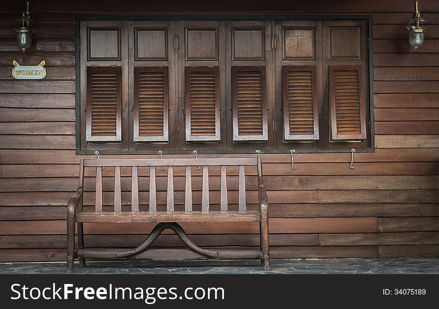 Wooden women restroom with wooden chair in front