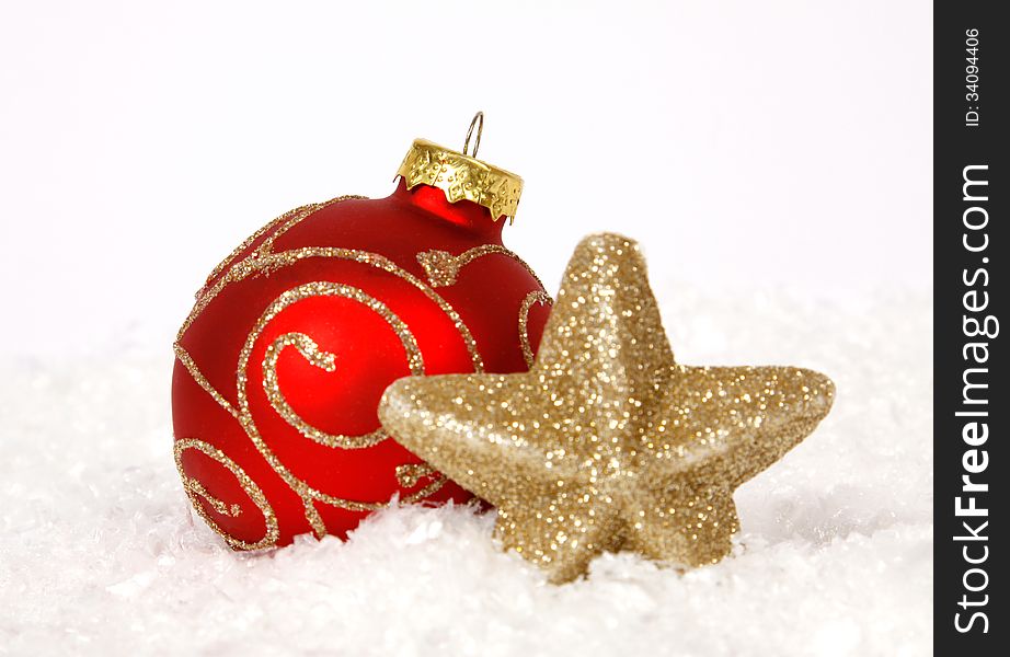 Red-golden baubles and golden star on the snow. Red-golden baubles and golden star on the snow
