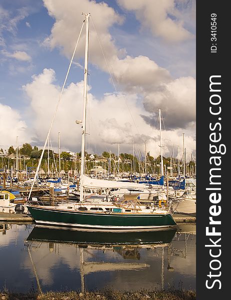 A green and white sailboat docked in a marina