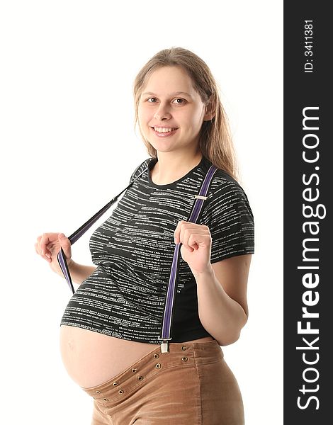 Happy young pregnant woman looking on a viewer and smiling. She is in black T-short , brown velvet pants with suspenders. Happy young pregnant woman looking on a viewer and smiling. She is in black T-short , brown velvet pants with suspenders