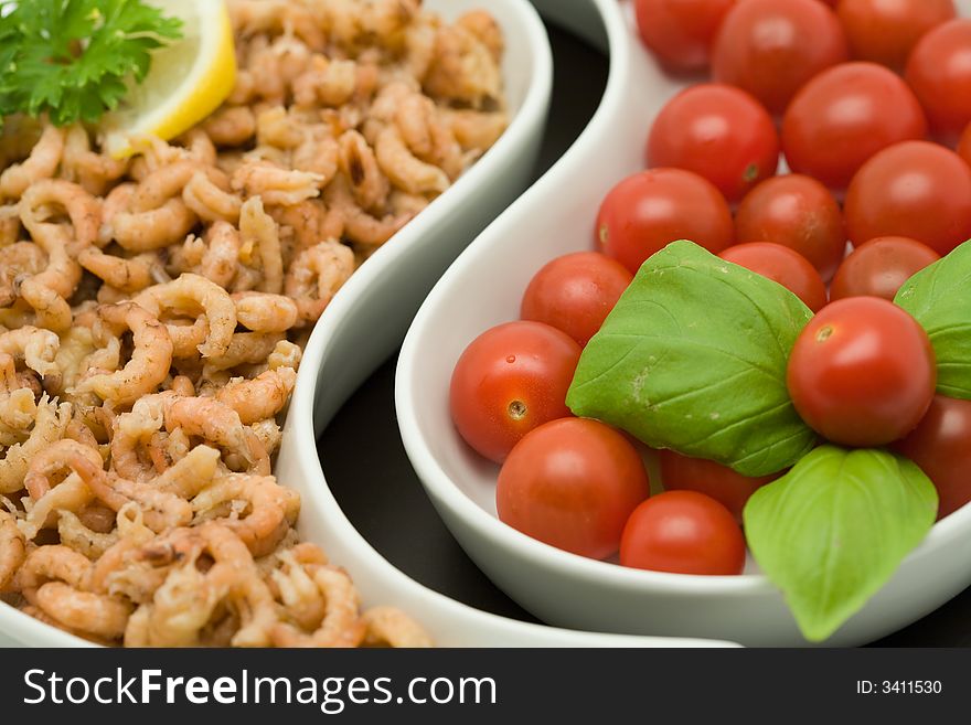 Shrimp and tomato appetizers decorated with persil, basil and a slice of lemon