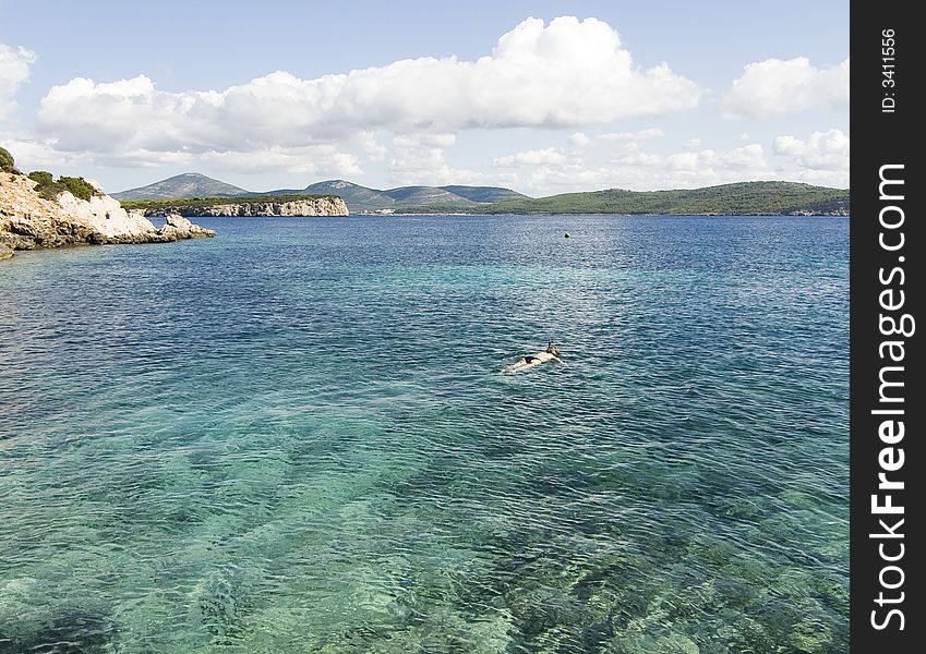 Bay at Capo Caccia and swimmer,  Sardinia, Italy. Bay at Capo Caccia and swimmer,  Sardinia, Italy.