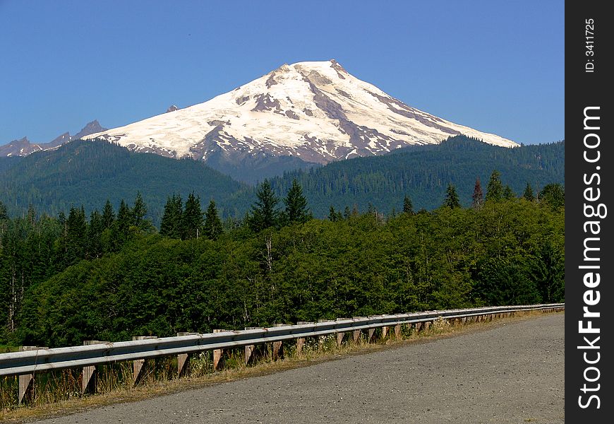 A shot of a mountain with a road in the foreground. A shot of a mountain with a road in the foreground.