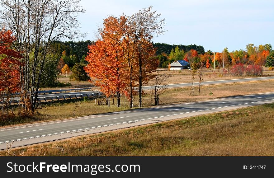 High way through colorful trees during autumn time. High way through colorful trees during autumn time