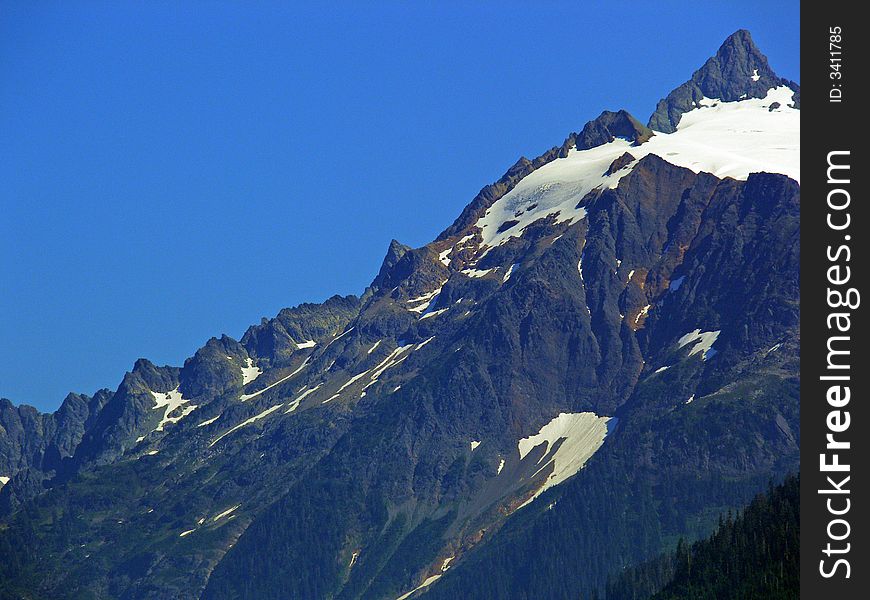 A shot of the side of a mountain with snow caps. A shot of the side of a mountain with snow caps.