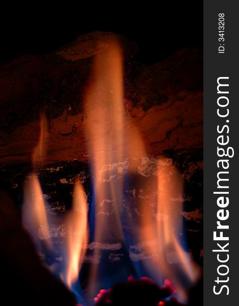 Closeup of flames in a fireplace with burning wooden log