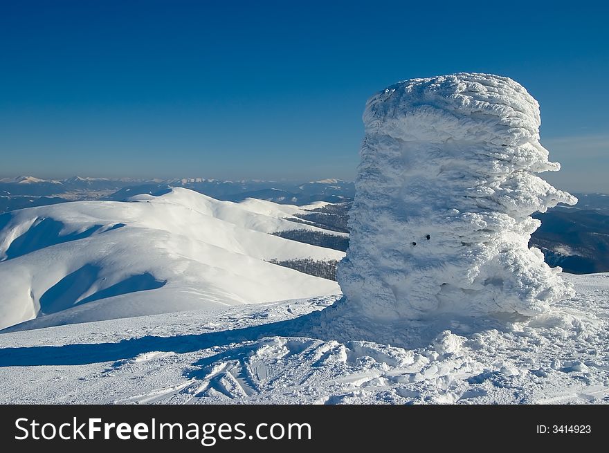 There are winter Mountains with triangulation mark on foreground.