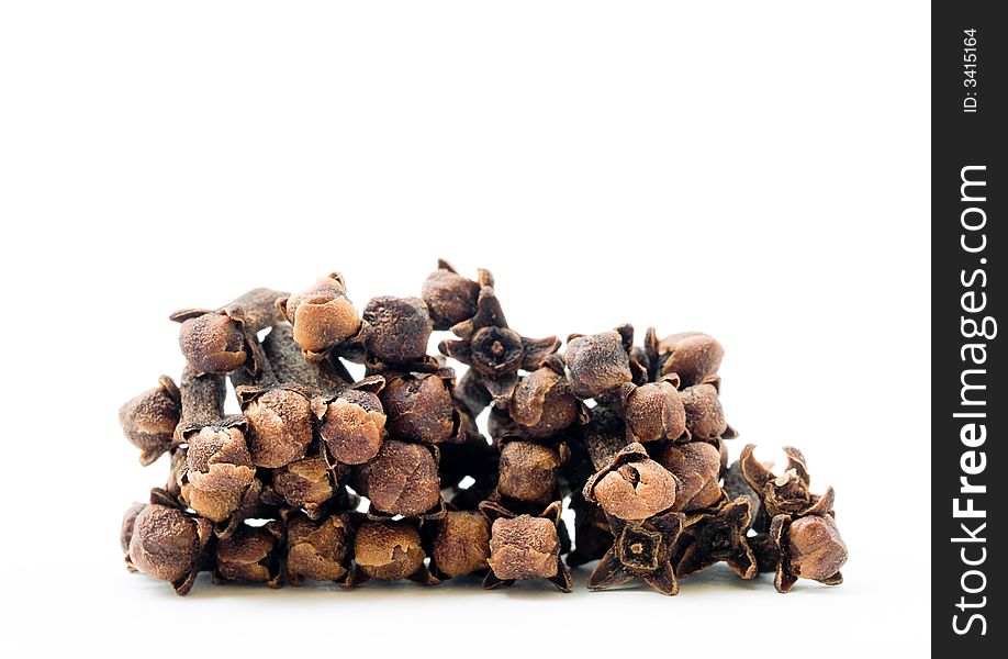 Still life of fragrant cloves stacked and isolated on white background. Still life of fragrant cloves stacked and isolated on white background.